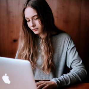 A girl utilizing digital marketing services at a table with a laptop.